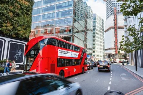 Red Double Decker Bus Driving Through London Street 库存照片