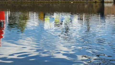 A red double decker bus pass through on a brick bridge reflected in a pond Stock Footage 104256847