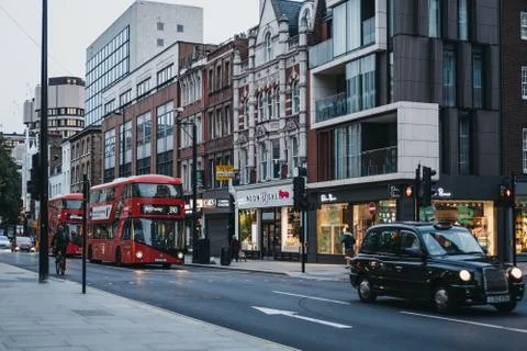 Red double decker buses and cars on Tottenham Court Road, London, UK, in the  Stock Photos
