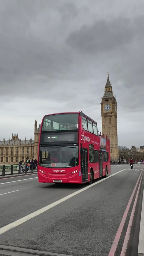 Red double-decker buses crossing Westminster Bridge, Big Ben, London Stock Footage 323588485