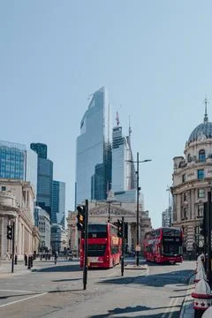 Red double decker buses on a road by the Bank Underground station in the City Stock-Fotos