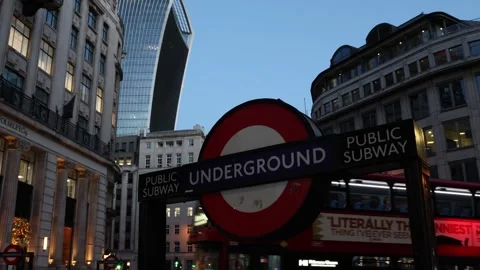 Red double decker busses passing London underground sign, city center street Видео 331666166