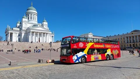 Red double-decker sightseeing bus parked in front of Helsinki Cathedral on a Stock Photos