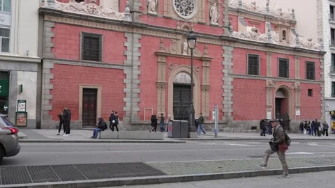 Red double decker tour bus passing historic building in Madrid, capturing Stock Footage 334291181