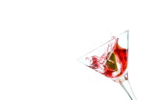 Red drink with lime falling into glass Foto stock