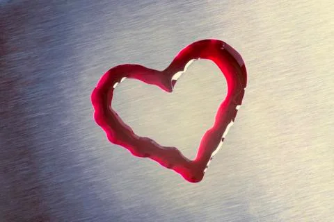 Red drops in the form of heart. The surface is metallic. Valentine's Day Stock Photos