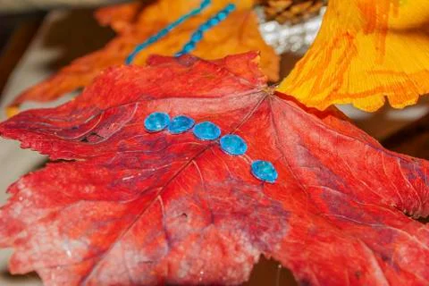 Red dry leaf tree decoration closeup with some blue sparkles. Can be used as gre 스톡 사진