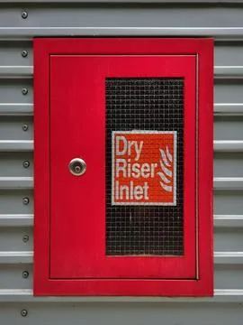 Red dry riser Inlet cabinet with lockable door and glass window on building Stock Photos