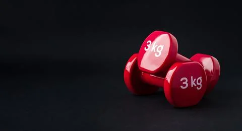 Red dumbbells on dark background dramatic fitness strength concept Stock Photos