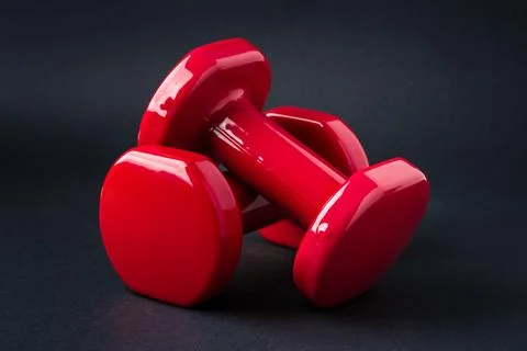 Red dumbbells pair representing strength balance and fitness training concept Stock Photos