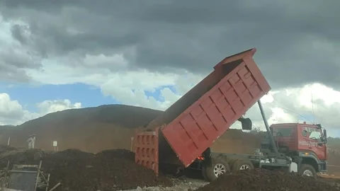 ​Red Dump Truck Unloading Soil at Construction Site Stock Footage 337288433