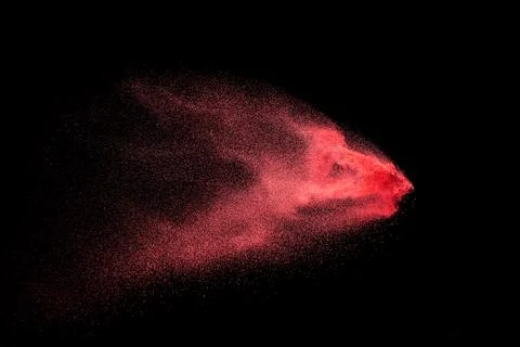 Red dust particles explosioon on black background.Red powder splash. Stock Photos