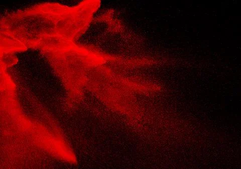 Red dust particles explosioon on black background.Red powder splash. Stock Photos