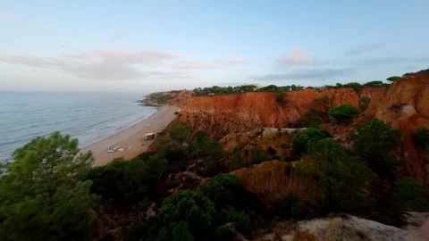 Red earth cliffs overlook turquoise sea Video stock 346090589