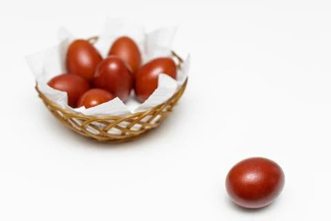 A red easter egg lies on the background of a basket with eggs Stock Photos