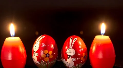 Red easter egg shape candles burning, with two wooden eggs Stock-Footage 48644599