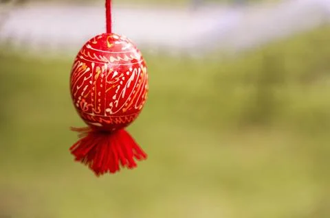 Red Easter egg with white traditional patterns on a tree branch Stock Photos