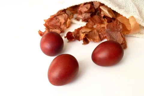 Red Easter eggs and bag with onion husks view from above. Dyeing eggs with on Stock Photos