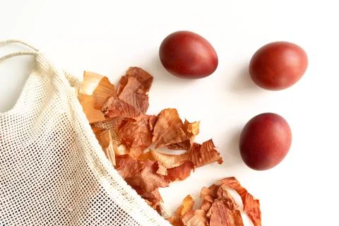 Red Easter eggs and bag with onion husks view from above. Dyeing eggs with on Stock Photos