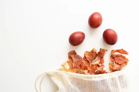 Red Easter eggs fly out of the bag with onion husks view from above with copy Stock Photos