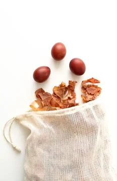 Red Easter eggs flying out of a bag of onion husks. Easter traditions. Dyeing Stock Photos