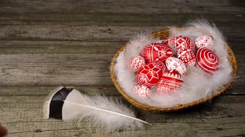 Red easter eggs with folk pattern inside basket. Man rotate egg on boards Video stock 127886611