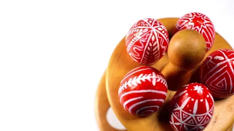 Red easter eggs with folk pattern lay and revolve on wooden stand for eggs Stock-Footage 127886689