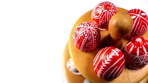 Red easter eggs with folk pattern lay and revolve on wooden stand for eggs Stock Footage 127886729