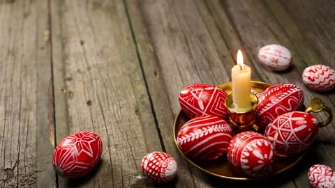Red easter eggs with folk Ukrainian pattern lay around and on candlestick Stock-Footage 127887291