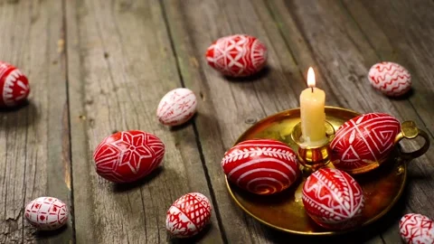 Red easter eggs with folk Ukrainian pattern lay around and on candlestick Video stock 127887320