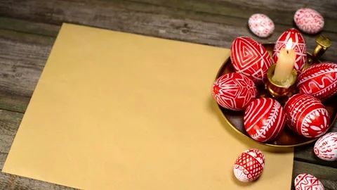 Red easter eggs with folk Ukrainian pattern lay on candlestick on vintage paper Stock Footage 127887378