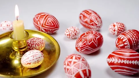 Red easter eggs with folk Ukrainian pattern lay around and on candlestick Stock Footage 127888535