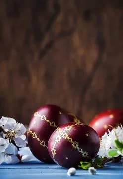 Red Easter eggs. white flowers and willow branches on gentle Easter blue wood Stock Photos