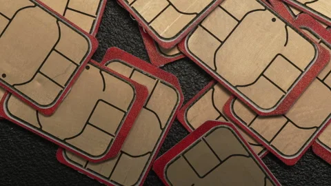 Red-Edged SIM Cards Overlapping on Textured Black Background Stock Footage 336475853