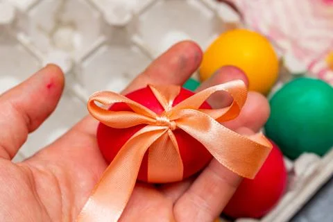 Red egg with bow in hands for the Easter Stock Photos