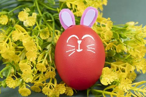 Red egg with easter rabbit drawn on green background Stock Photos