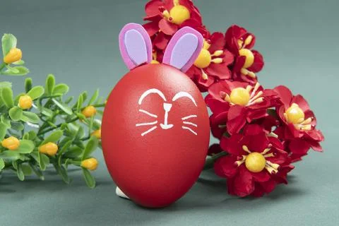 Red egg with easter rabbit drawn on green background Stock Photos