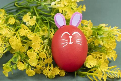 Red egg with easter rabbit drawn on green background Foto stock