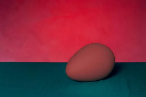 Red egg on green table and red background. Stock Photos