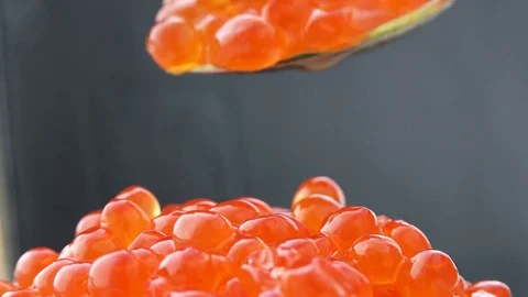 Red eggs dripping from a spoon of caviar on the mountain, and conceal in their Stock Footage 71128620