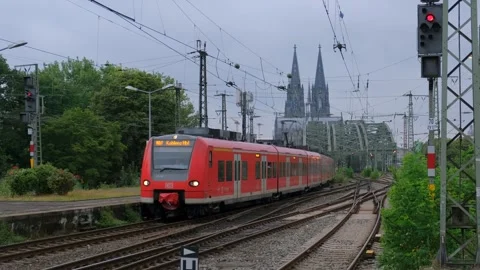 Red electric passenger commuter train moving on tracks towards city center Vídeo Stock 337405161