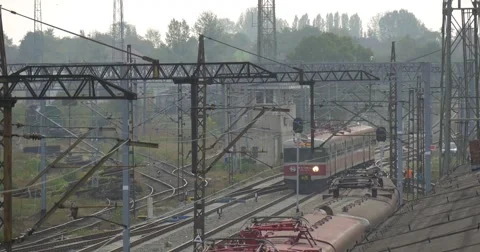 Red Electric Train Moves Away Railroad Tracks And Contact Network Lamp Posts Stock Footage 55299097