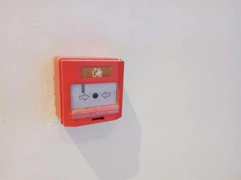 RED ELECTRONIC FIRE BUTTON ALARM SWITCH ON WHITE WALL. FIRE WARNING DEVICE Stock Photos