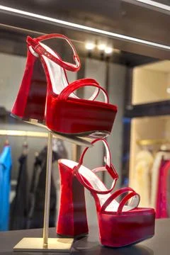Red elegant platform and high heel sandals on shoe store showcase Stock Photos