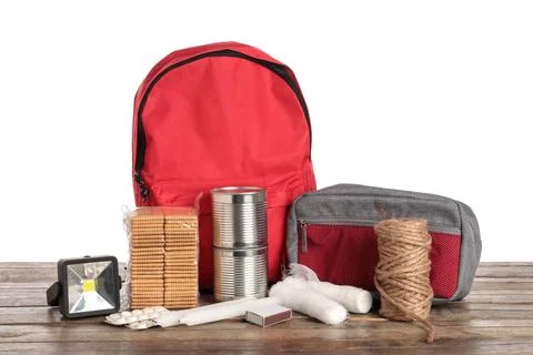 Red emergency backpack with necessities on table against white background Stock Photos