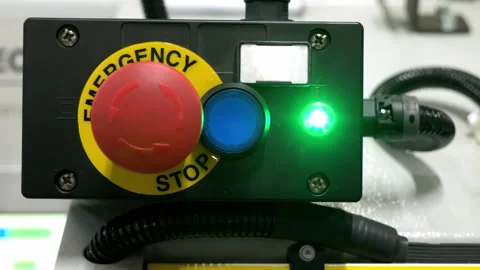 Red emergency stop button with green status light on industrial machine panel Stock Footage 328644899