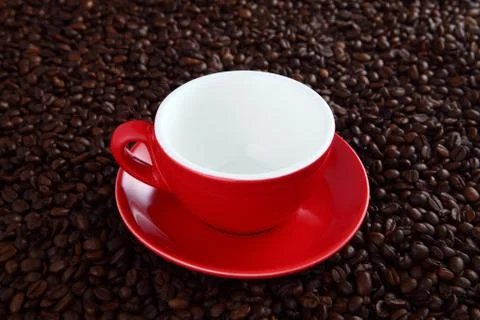 Red empty coffee cup with coffee beans as background Stock Photos
