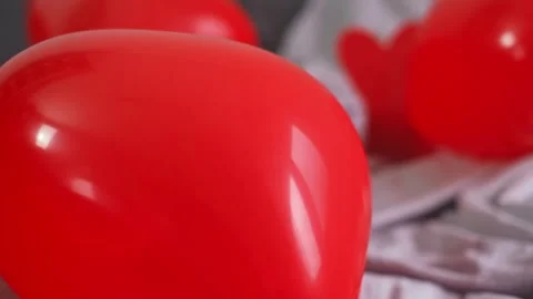 A red engagement ring box lies on a couch surrounded by heart-shaped balloons, c Stock Footage 298184502