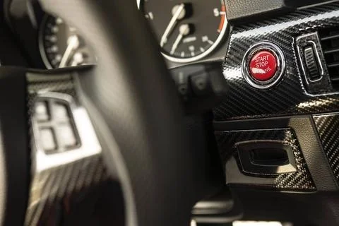 Red engine start button detail. Car dashboard with focus on red engine sta... Stock Photos