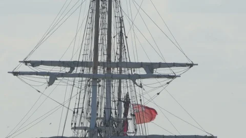 A red ensign flag flying a loft on a square rigged sailing vessel Stock Footage 93515957